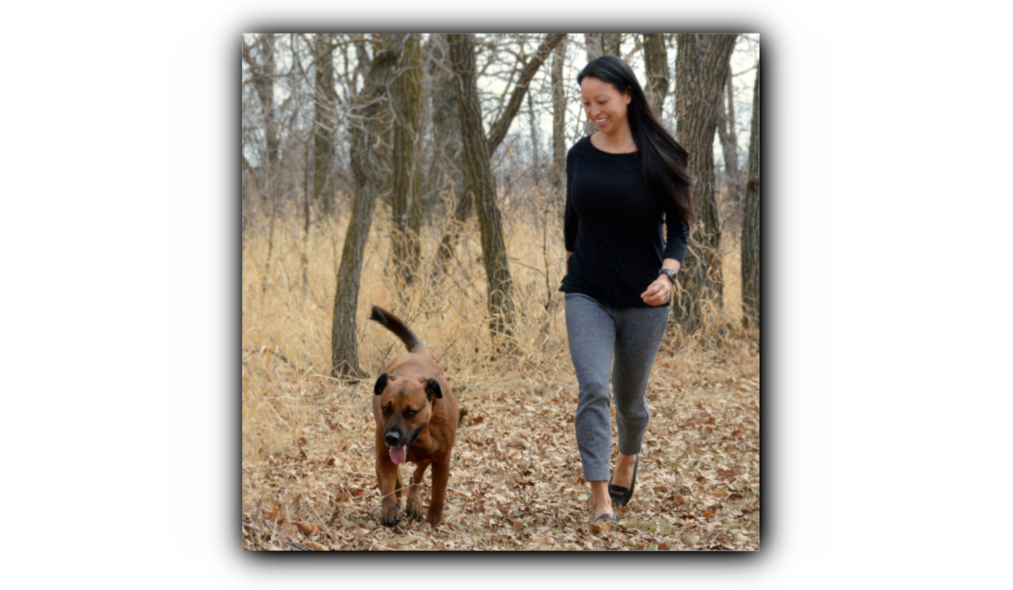Dr. Amber Ly and her dog Robbie on a leisurely stroll through a wooded area. She is a veterinarian and the owner of Prairie Ly Mobile Veterinary Care, a mobile veterinary service in Winnipeg, Manitoba.  